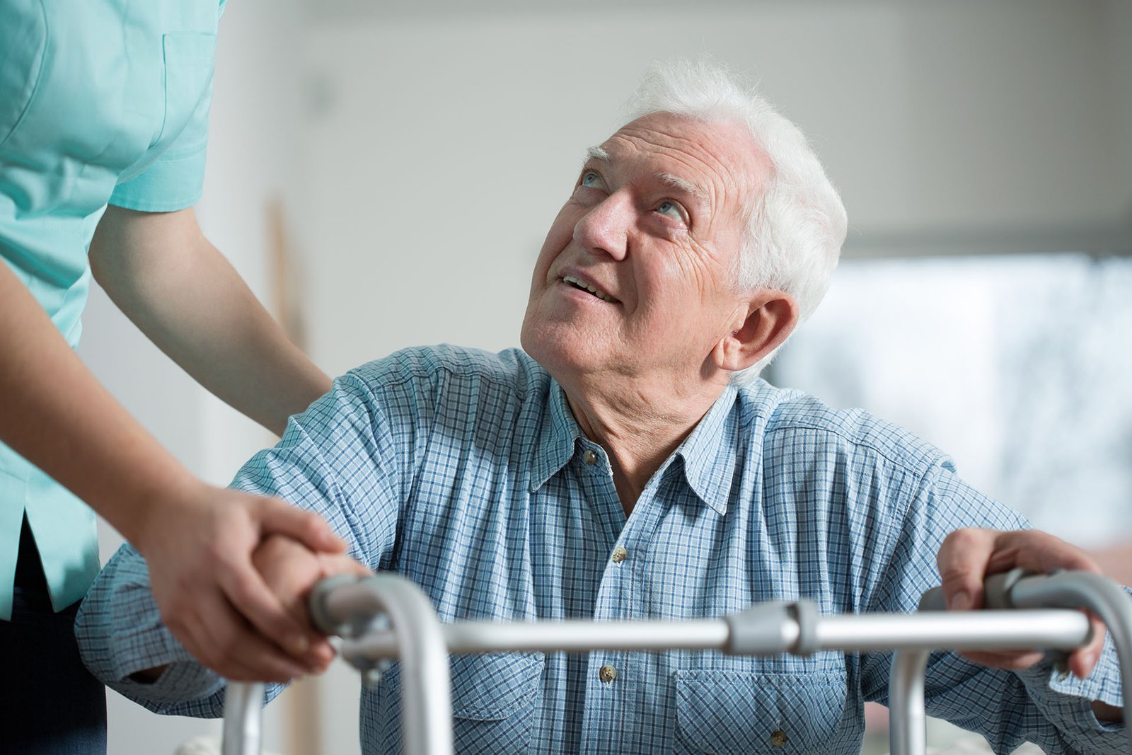 Close-up of aged man trying to stand up with walker